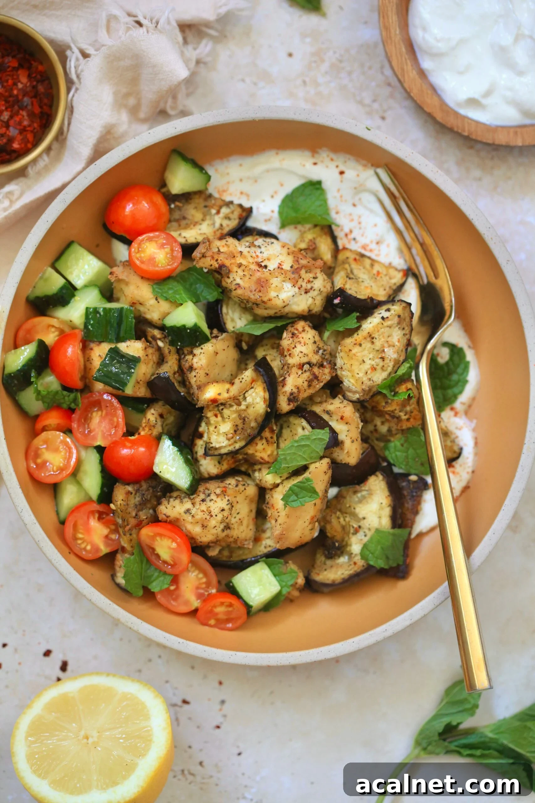 Mediterranean Tofu & Roasted Eggplant with Tahini Yogurt Sauce 9 bowl with tofu, veggies, white sauce and gold fork.