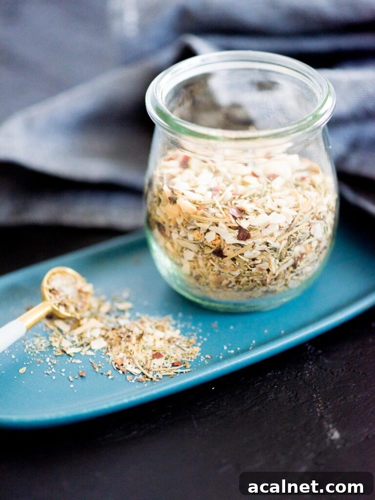 tuscan herb seasoning blend in a jar with a measuring spoon and plate