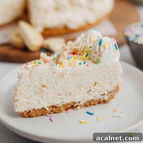 A slice of no bake cheesecake covered in rainbow sprinkles on a small beige plate