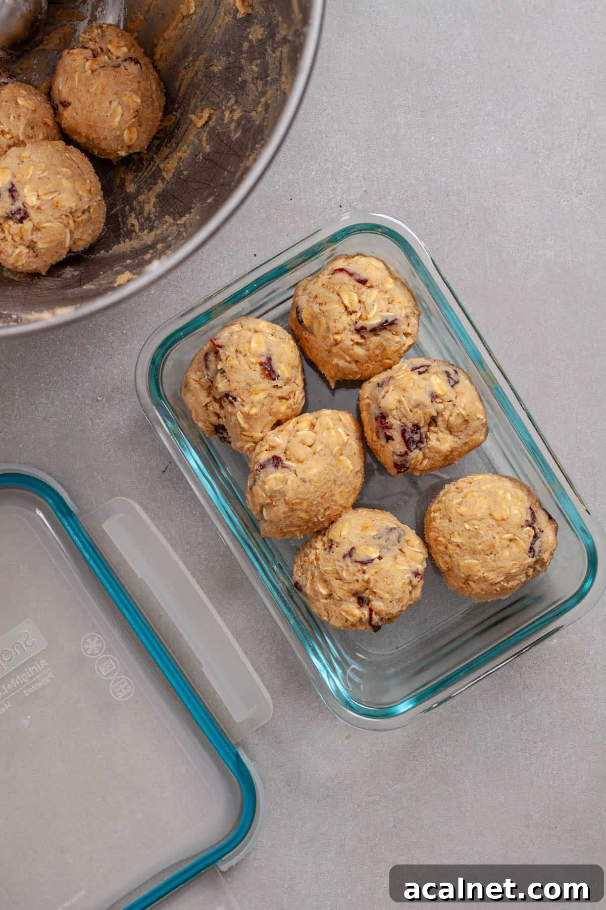 A glass container with portions of oatmeal cherry cookie balls.