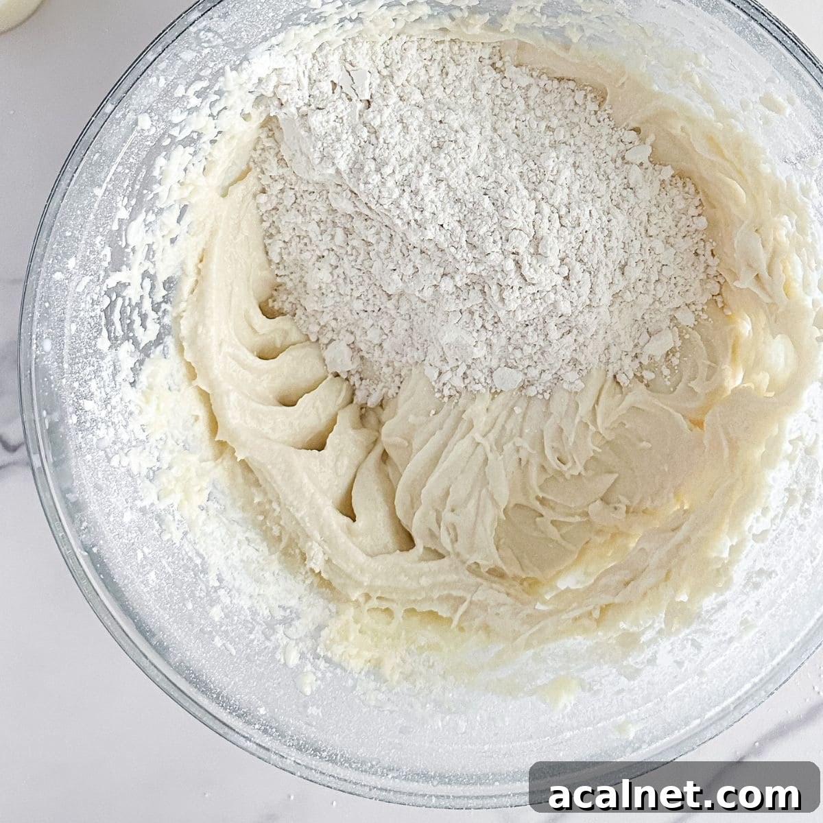 Adding the dry ingredients to the creamed butter.