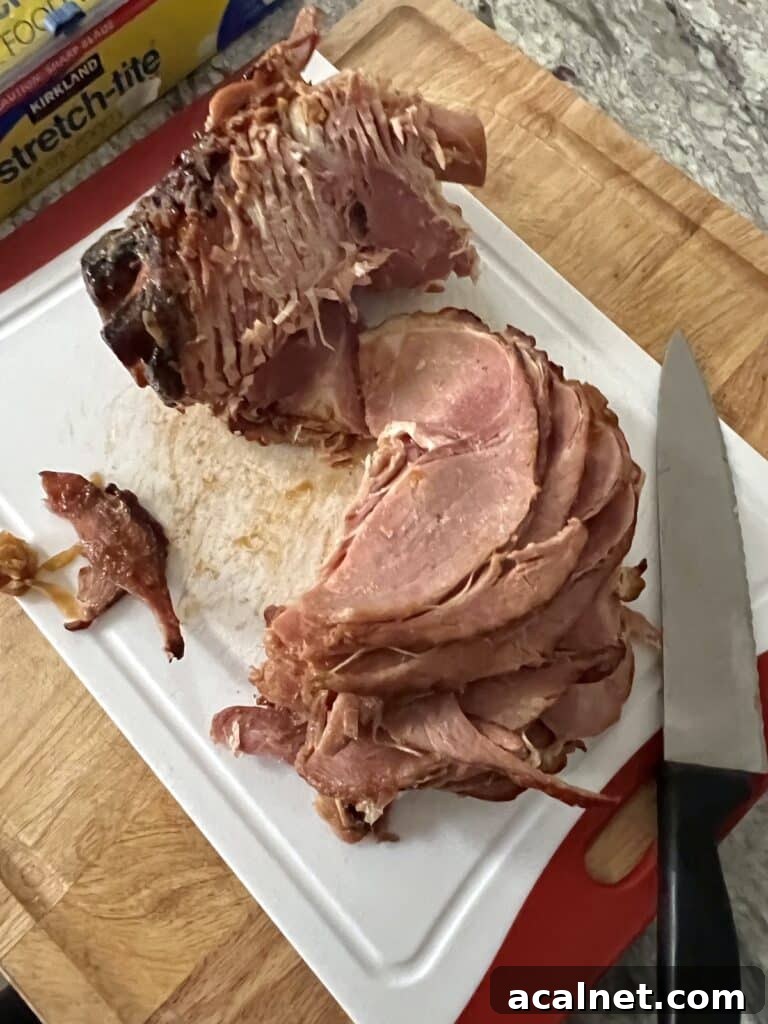 Can you refreeze ham that has been already baked? Photo of leftover ham being sliced for packaging in freezer.