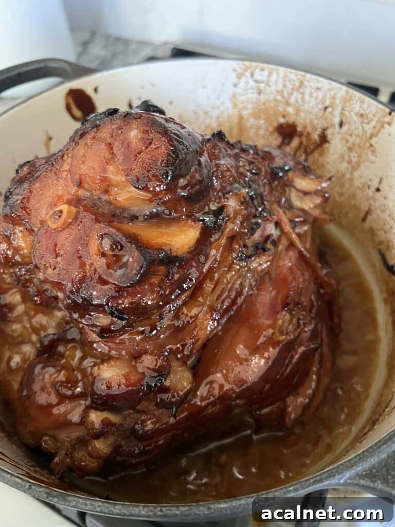 Baked glazed ham in Dutch oven ready to carve and serve.
