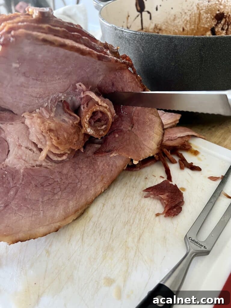 Carving baked ham on cutting board.