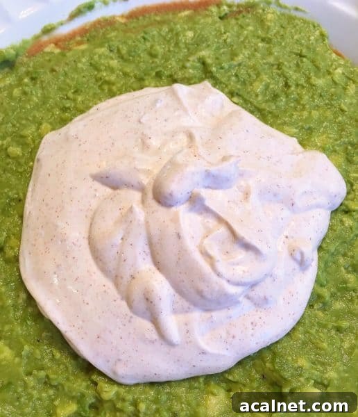 Sour cream taco seasoning mixture on top of guacamole
