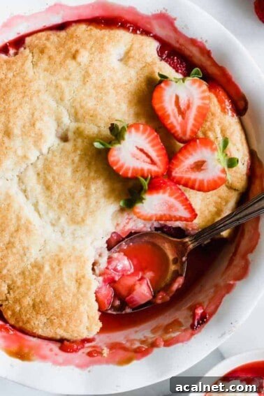 Spoon scooping out strawberry cobbler.