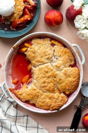 Baked peach cobbler in a round dish.