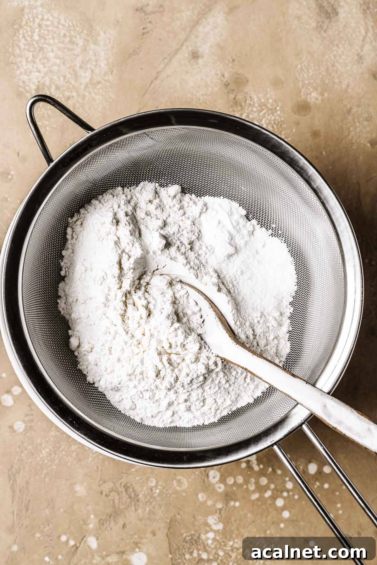 Dry ingredients being sifted into a bowl.