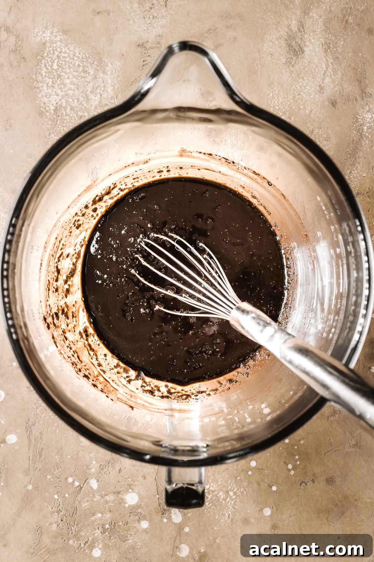 Whisked melted butter, cocoa powder and sugar in a mixing bowl.