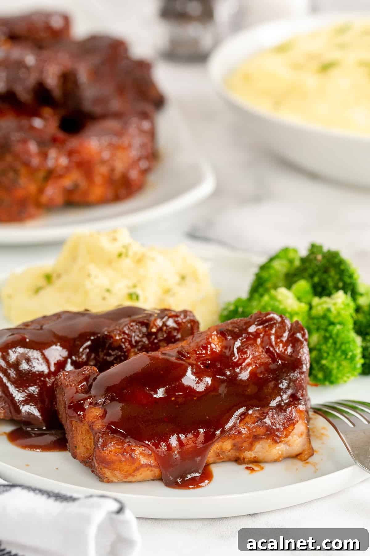 Country Style Ribs on a plate with mashed potatoes and broccoli.