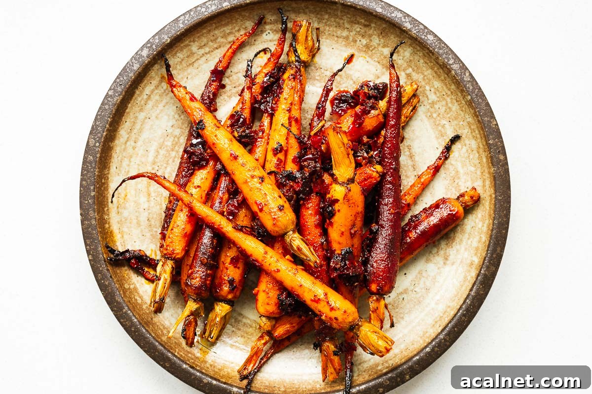 Harissa glazed carrots on a brown ceramic serving plate.