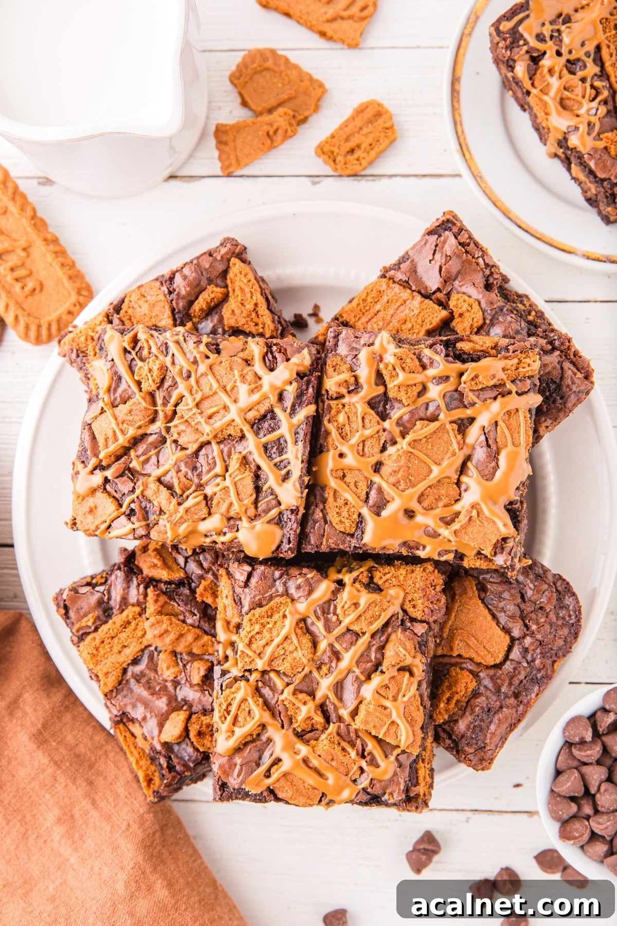 A plate of brownies topped with biscoff cookies and cookie butter.