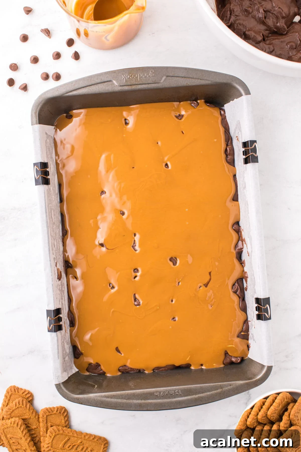 A baking pan filled with brownie batter and topped with cookie butter.