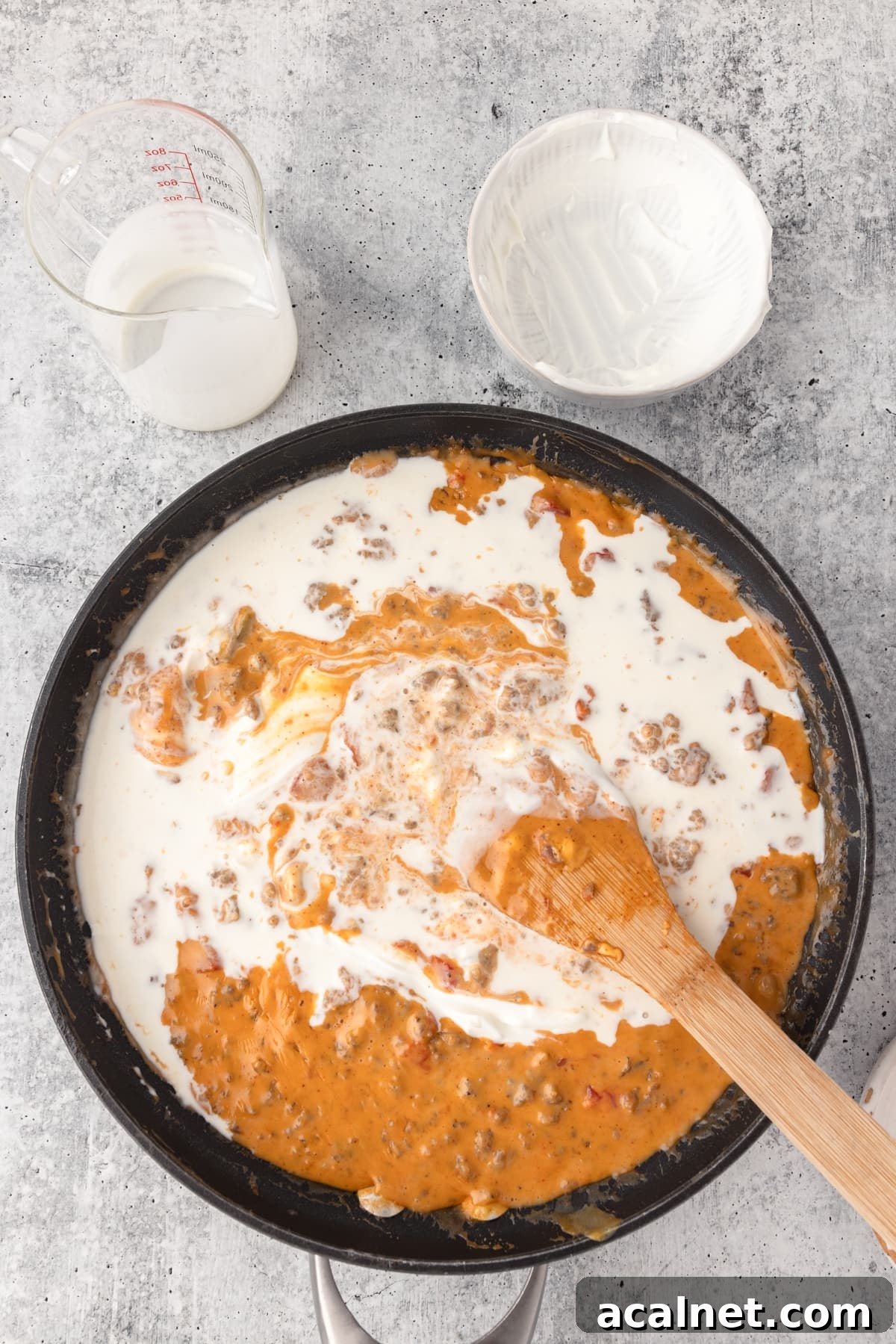 Mixing all the ingredients with a large wooden spoon for Velveeta cheese dip.