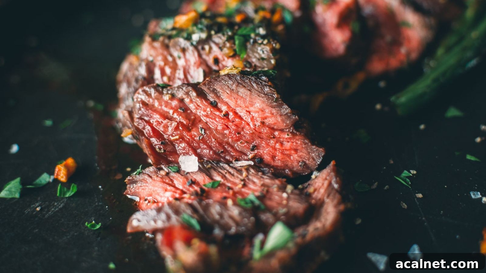 Grilled Denver steak with herb butter melting down over the warm sliced meat.