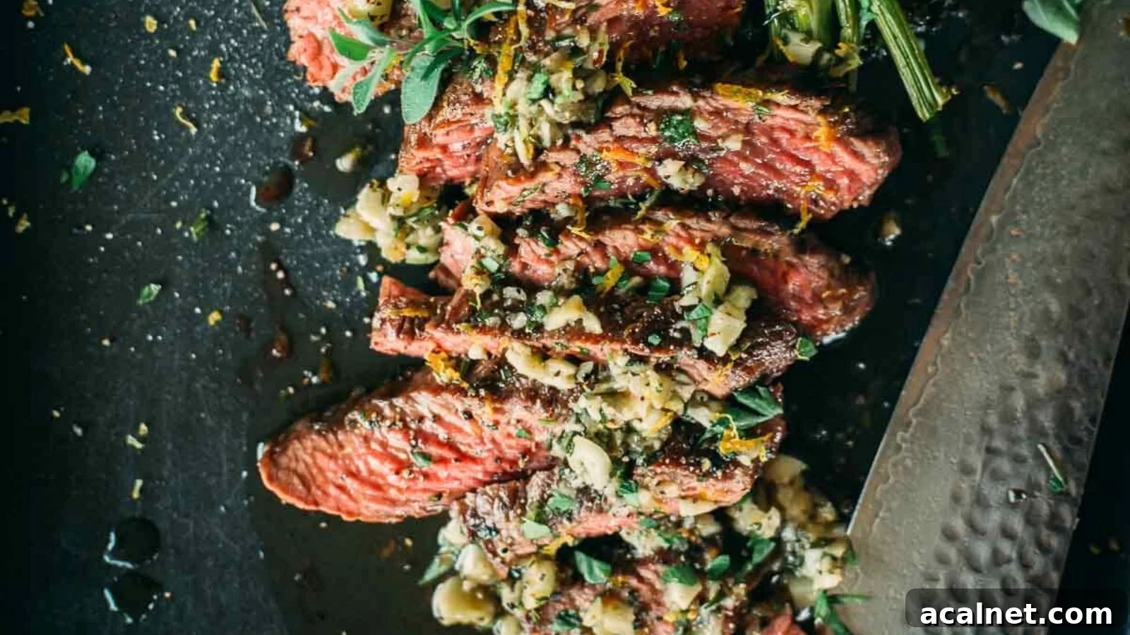 Garlic butter basted teres major steak sliced to show juicy interior with butter pooling beneath.