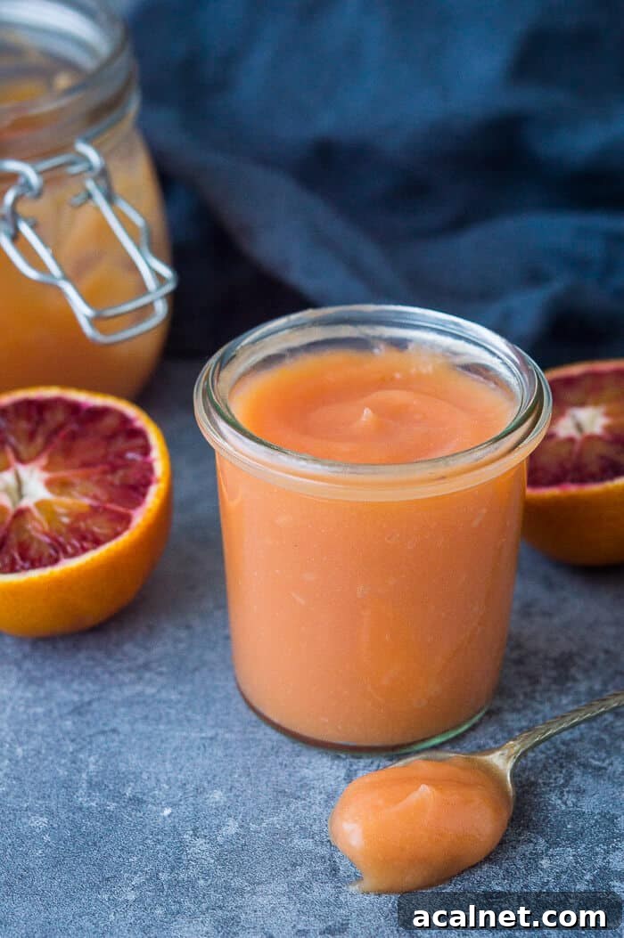 Vegan Blood Orange Curd Recipe — Silky, Zesty Spread 8 A small glass jar of vegan blood orange curd with a spoonful of curd in front of it.