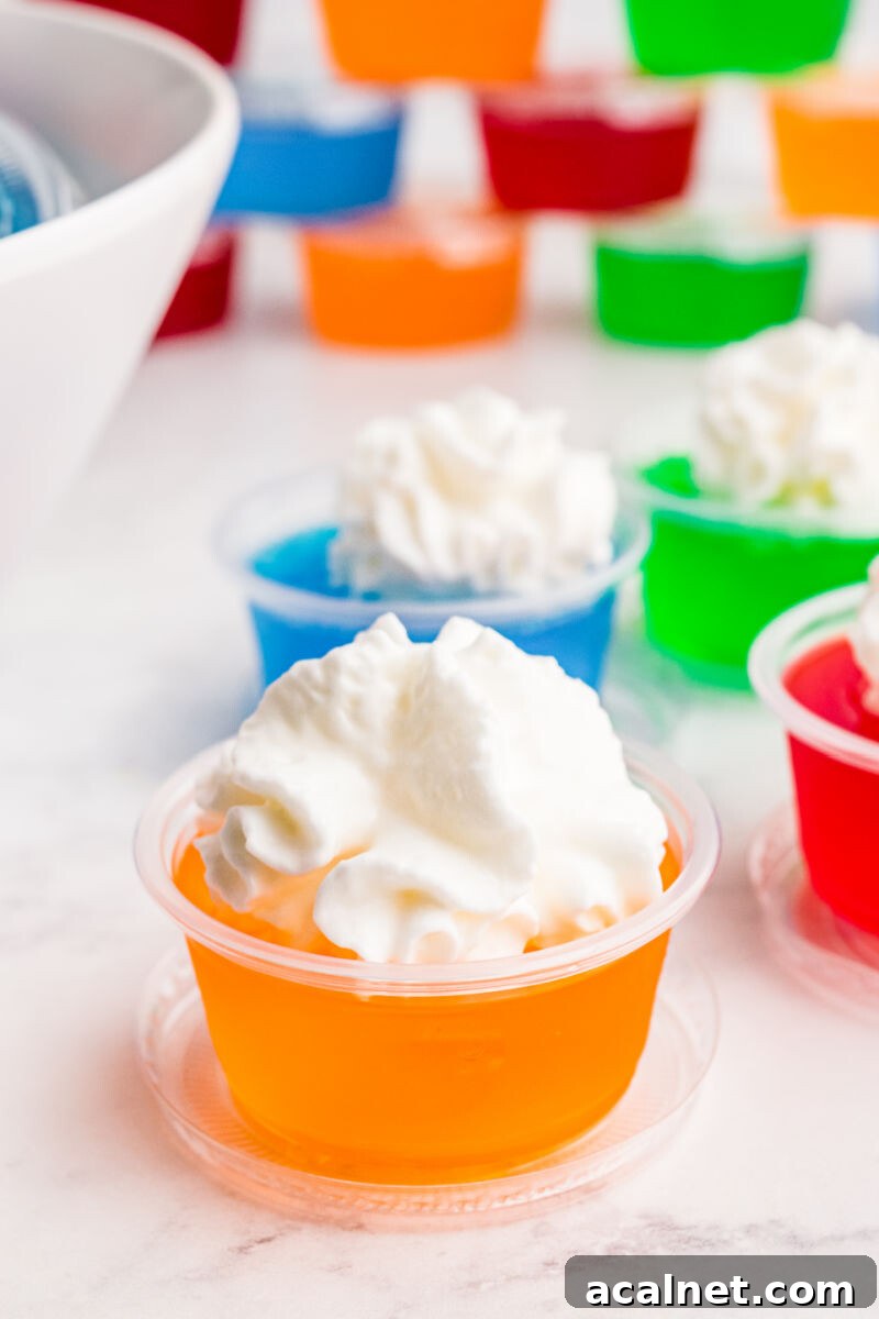 Vodka Jello Shot Recipe: Party-Friendly Jiggly Cocktails 6 close up of a jello shot with whipped cream on top
