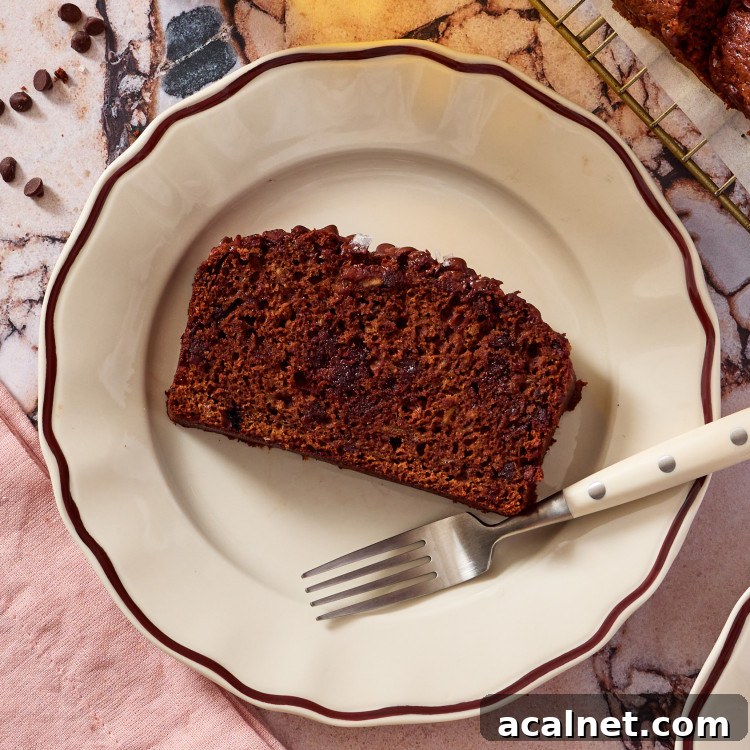 Olive Oil Chocolate Banana Bread Recipe for Moist Loaves 19 A slice of chocolate olive oil banana bread on a plate with a fork.