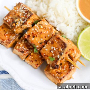 Creamy spicy peanut sauce on tofu satay.