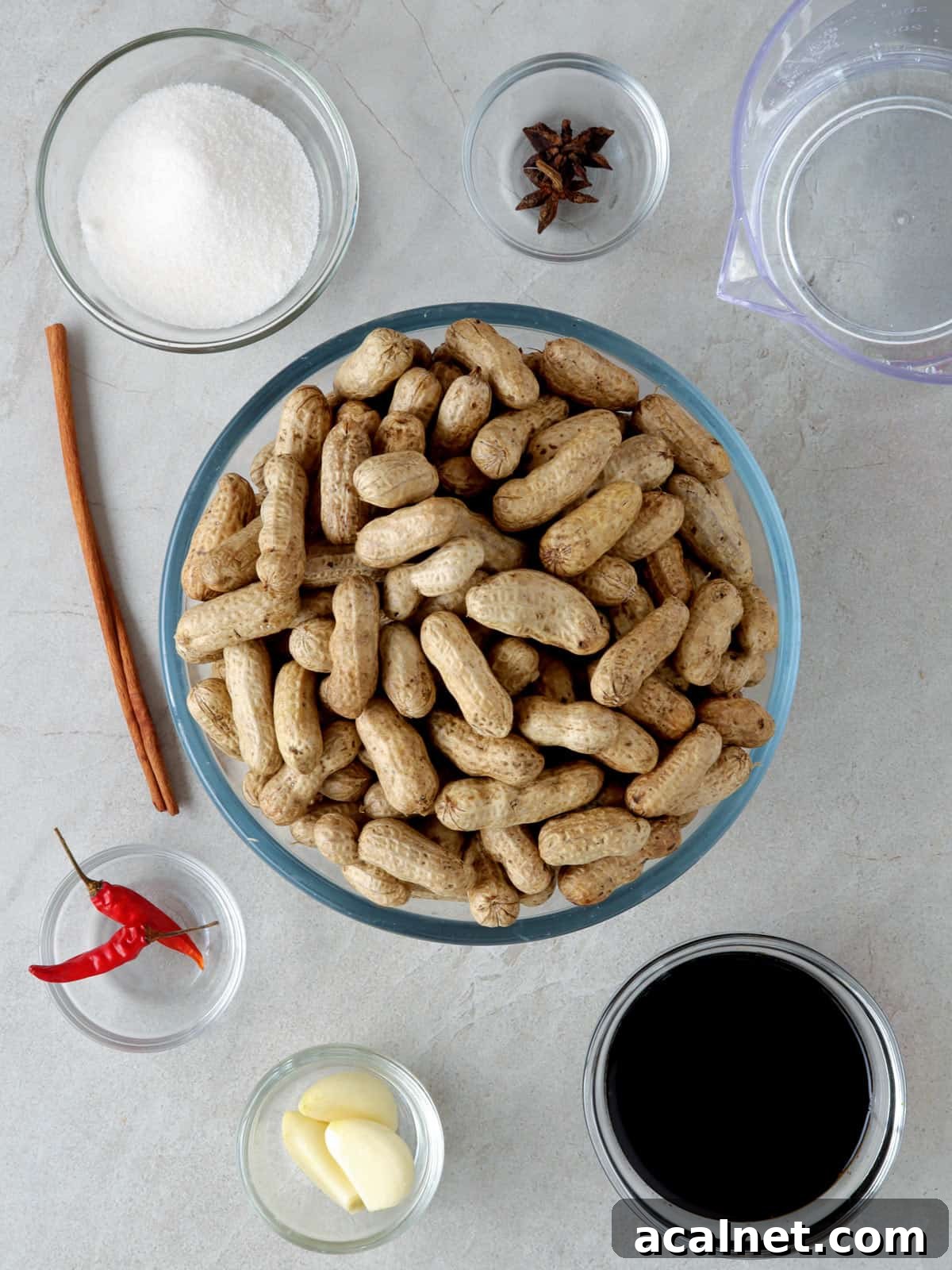 raw shell-on peanuts, soy sauce, sugar, chili peppers, garlic cloves, soy sauce, peppercorns, star anise in individual bowls