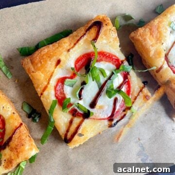 Puff pastry pizza on wooden board with balsamic drizzle.