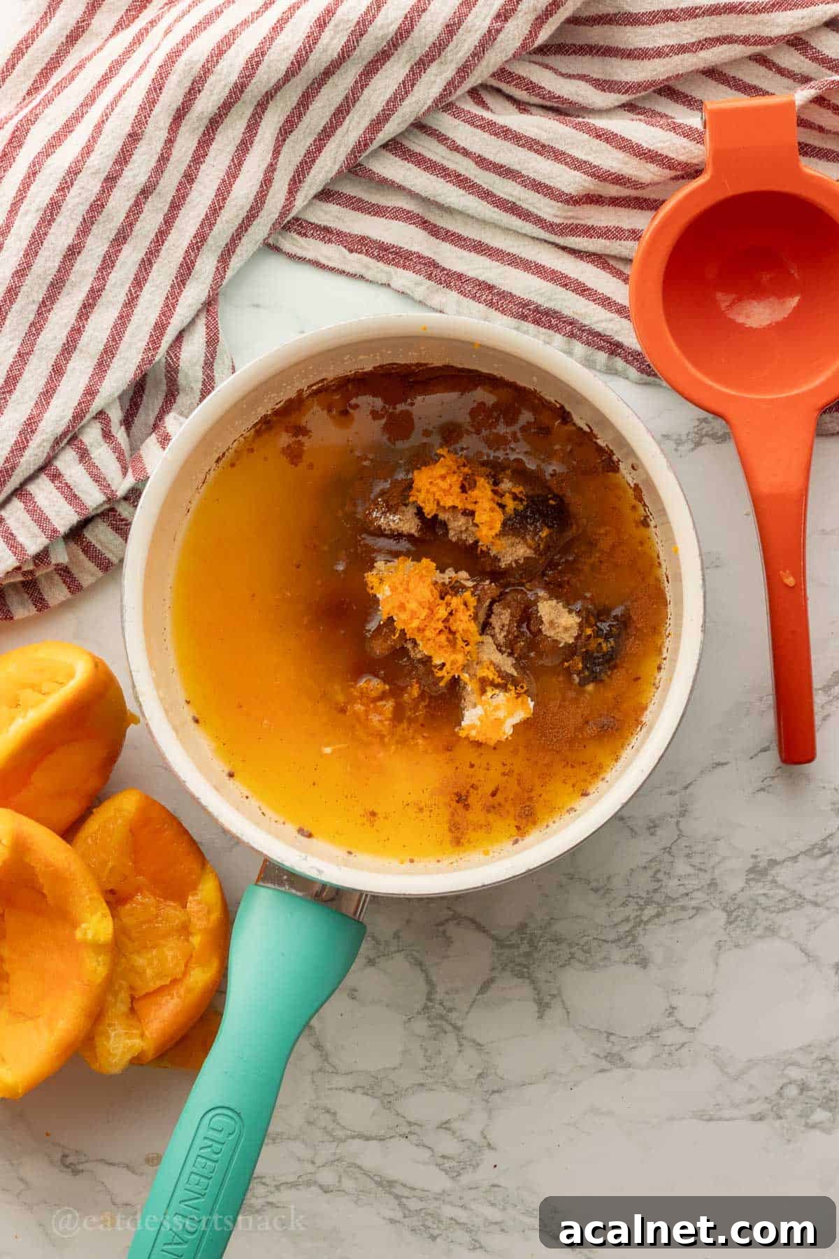 Orange zest, brown sugar, orange juice in metal cooking pan.