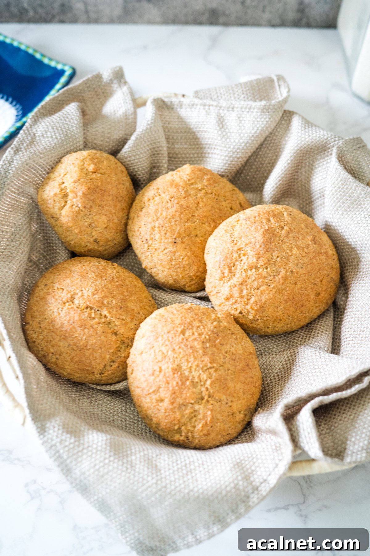 A bowl of flaxseed bread buns sitting on a table.
