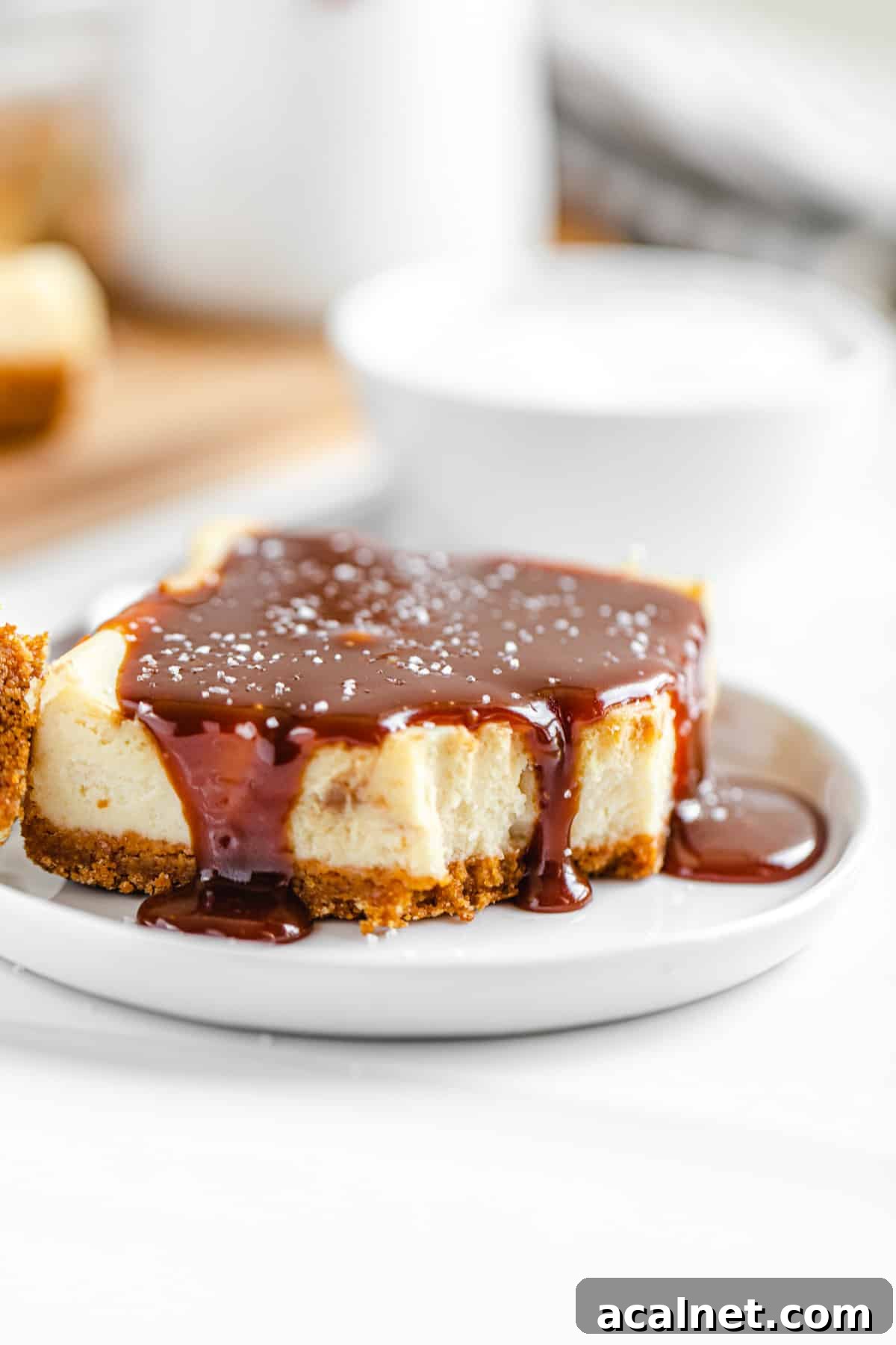 half-eaten caramel topped cheesecake bar on a small white plate