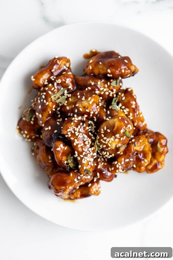 Crispy Air Fryer Sesame Chicken Bites — 62g Protein Per Serving 3 Top down view of air fryer sesame chicken bites with homemade sticky sesame sauce and toasted sesame seeds
