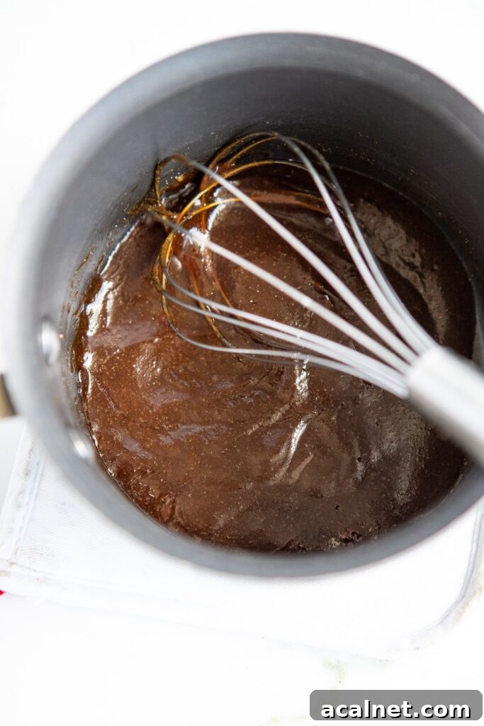 Crispy Air Fryer Sesame Chicken Bites — 62g Protein Per Serving 5 Homemade sesame chicken sauce in small saucepan with wire whisk — soy sauce honey ginger sesame oil