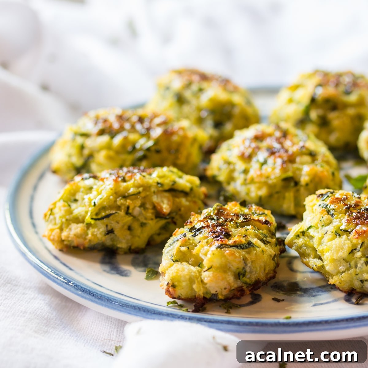Side view of zucchini tots arranged on a serving plate.