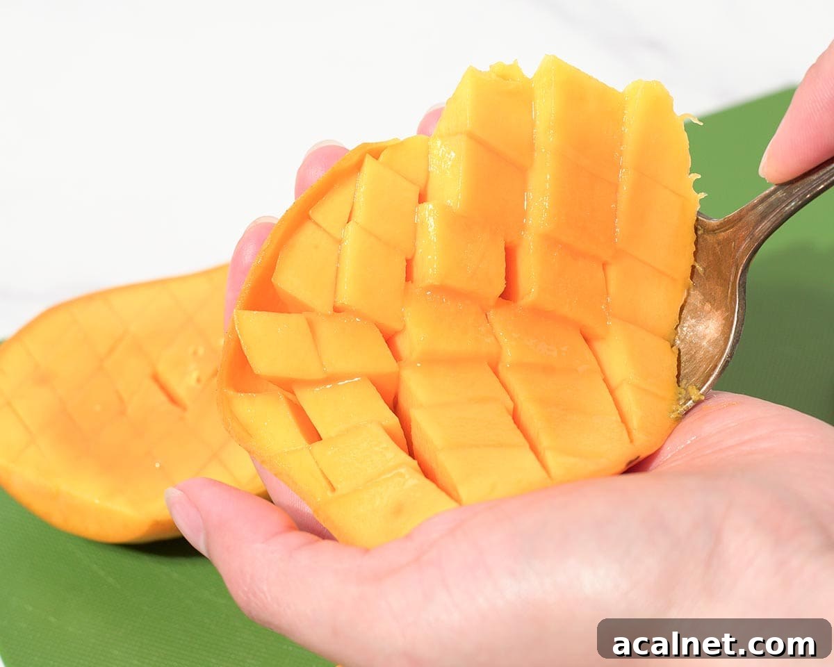 Using spoon to scoop our cubed mango.