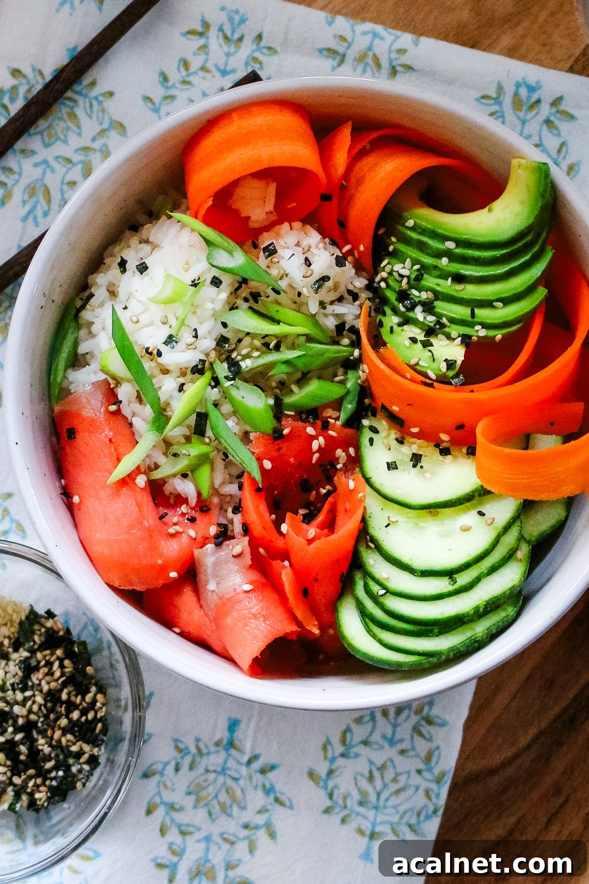 Smoked Salmon Poke Bowl with Avocado, Sesame and Lime 5 Smoked salmon in a white bowl, served with sesame seeds on the side.