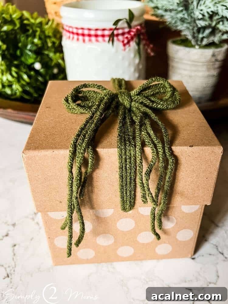 Kraft box with polka dot bottom and green yarn bow on the lid