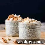 Creamy Banana Chia Seed Pudding Recipe 14 Two jars of banana chia pudding on a wooden board, topped with banana and granola.