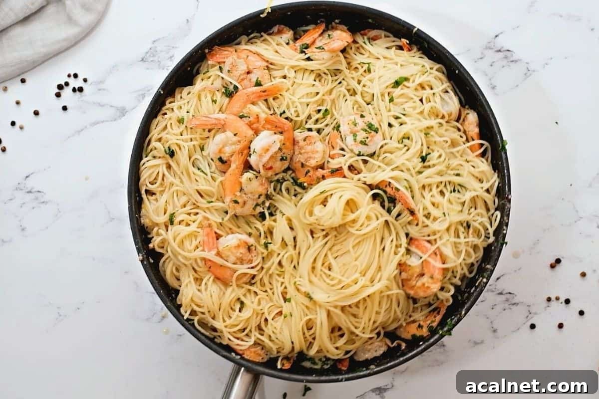 Shrimp Scampi with angel hair pasta in skillet.