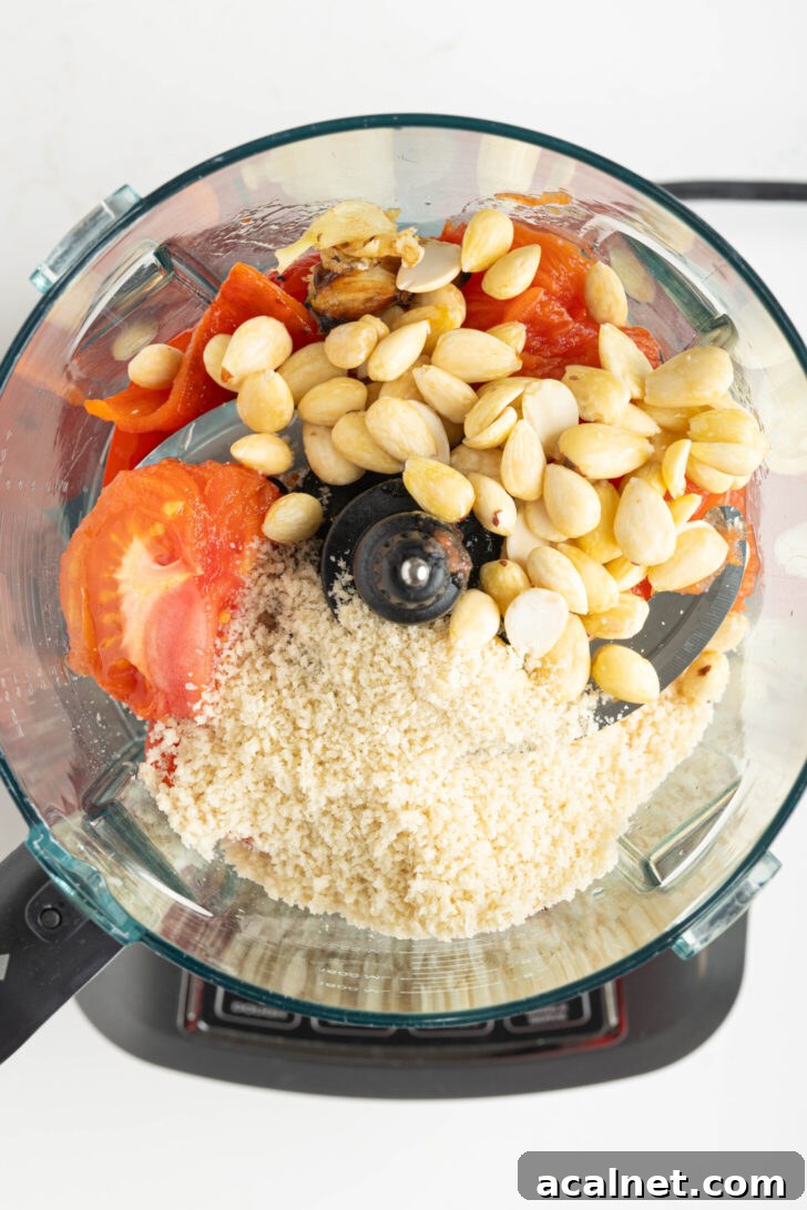 a food processor with almonds, bread crumbs, and more