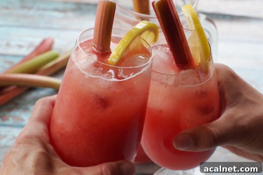 rhubarb lemonade in two glasses being clinked together