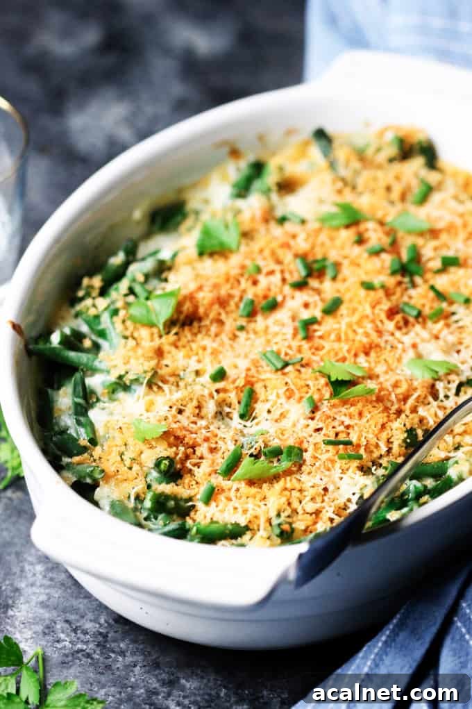 Creamy Cheddar Green Bean Casserole with Crispy Onions 3 Green bean casserole in a white dish with spoon