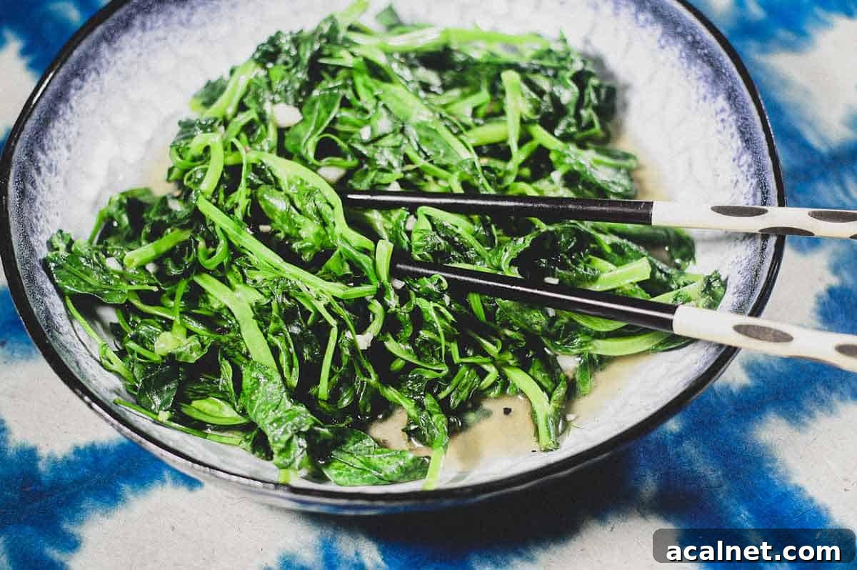 A platter of stir fried sno pea shoots on a blue batik background