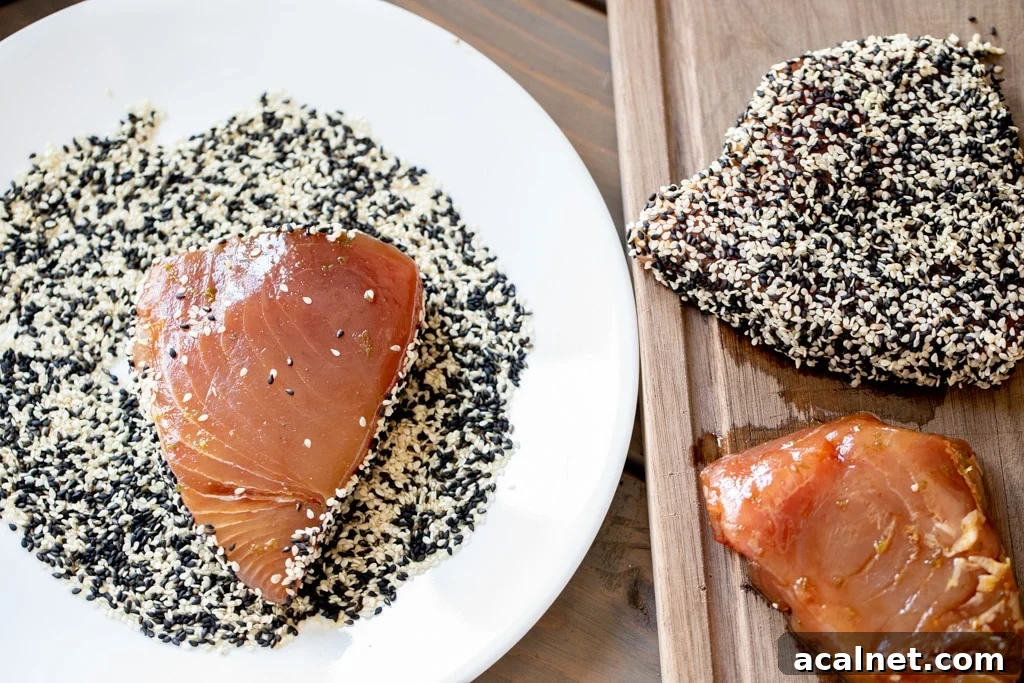 Marinated tuna steak on a plate of sesame seeds.