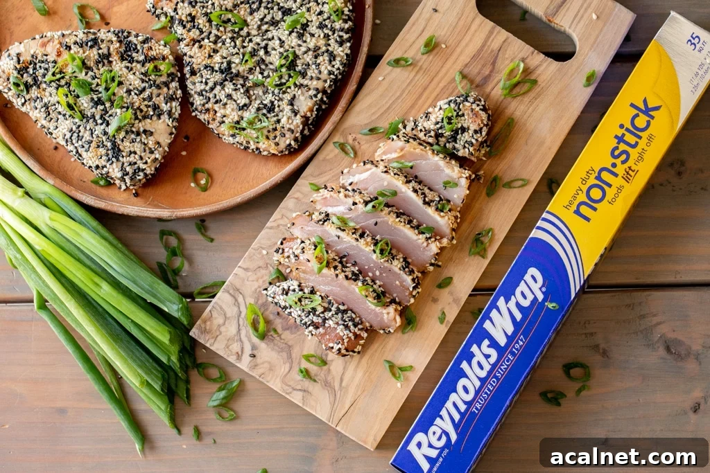 Grilled and sliced tuna steak on a wooden cutting board.