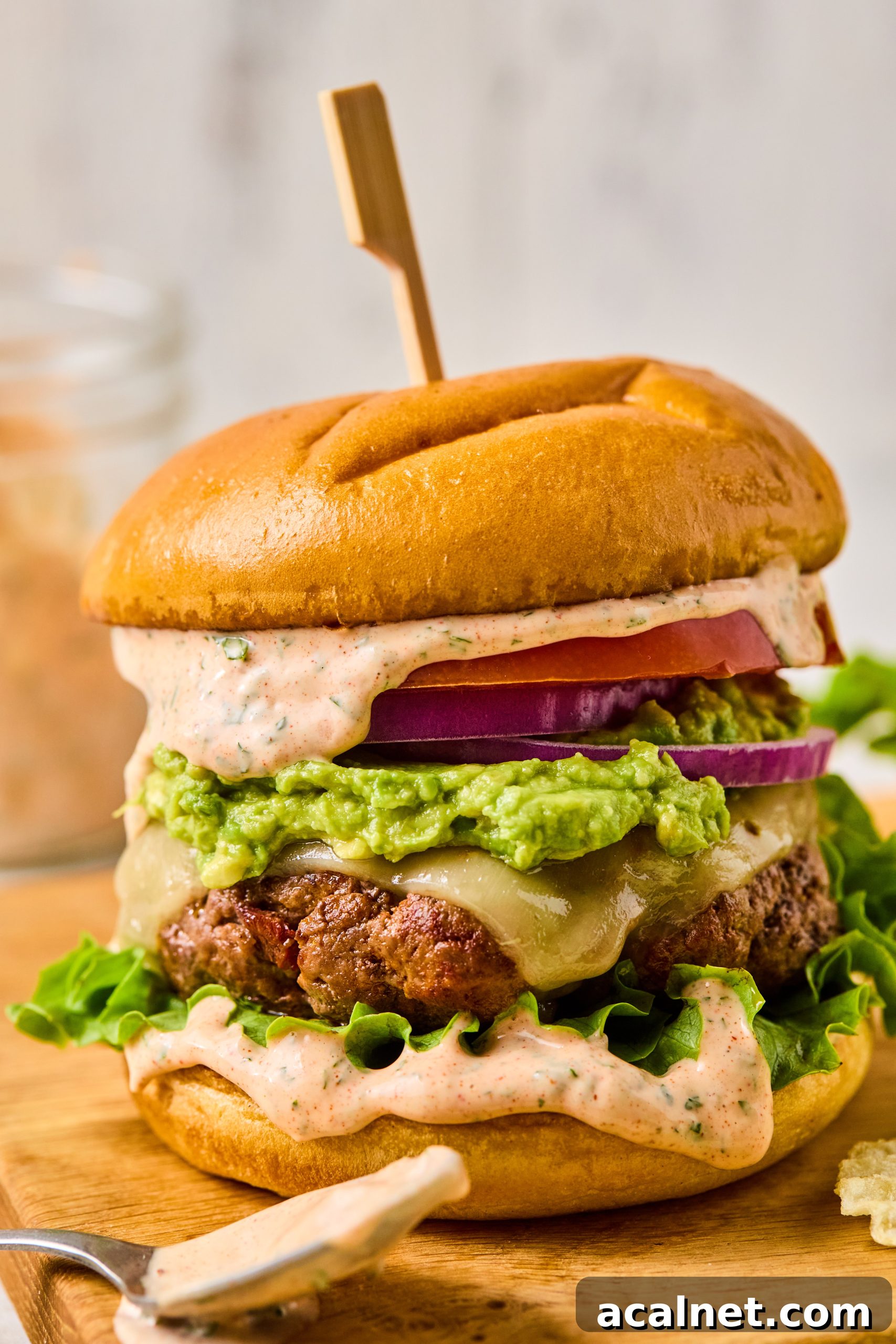 Smoky Chipotle Beef Burgers with Creamy Aioli 2 Smoky chipotle beef burgers made with chipotle beef patties, mashed avocado, cheese, tomatoes, red onion and a creamy homemade chipotle aioli on toasted hamburger buns