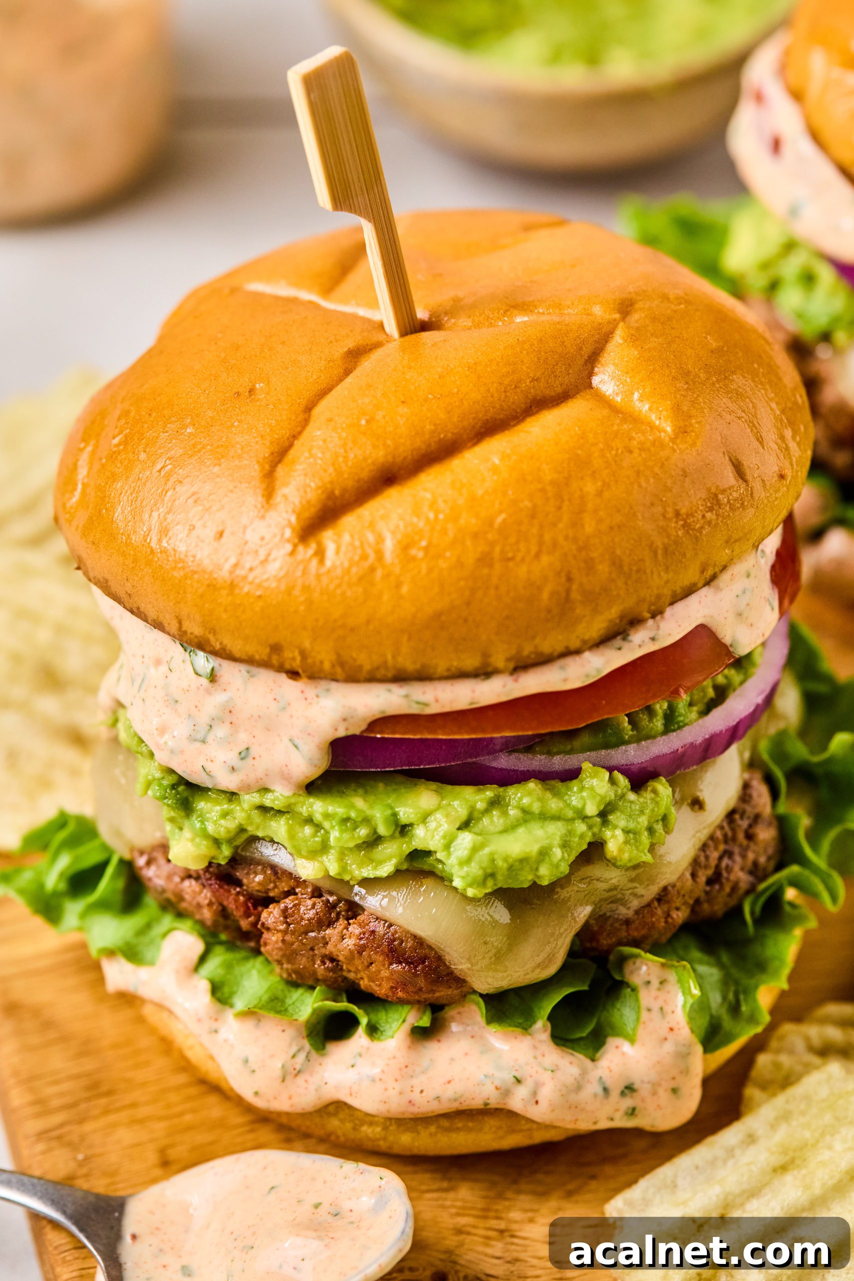 Smoky Chipotle Beef Burgers with Creamy Aioli 13 A close up photo of a smoky chipotle beef burger made with toasted brioche buns, homemade chipotle aioli, mashed avocado, tomato, red onion and lettuce