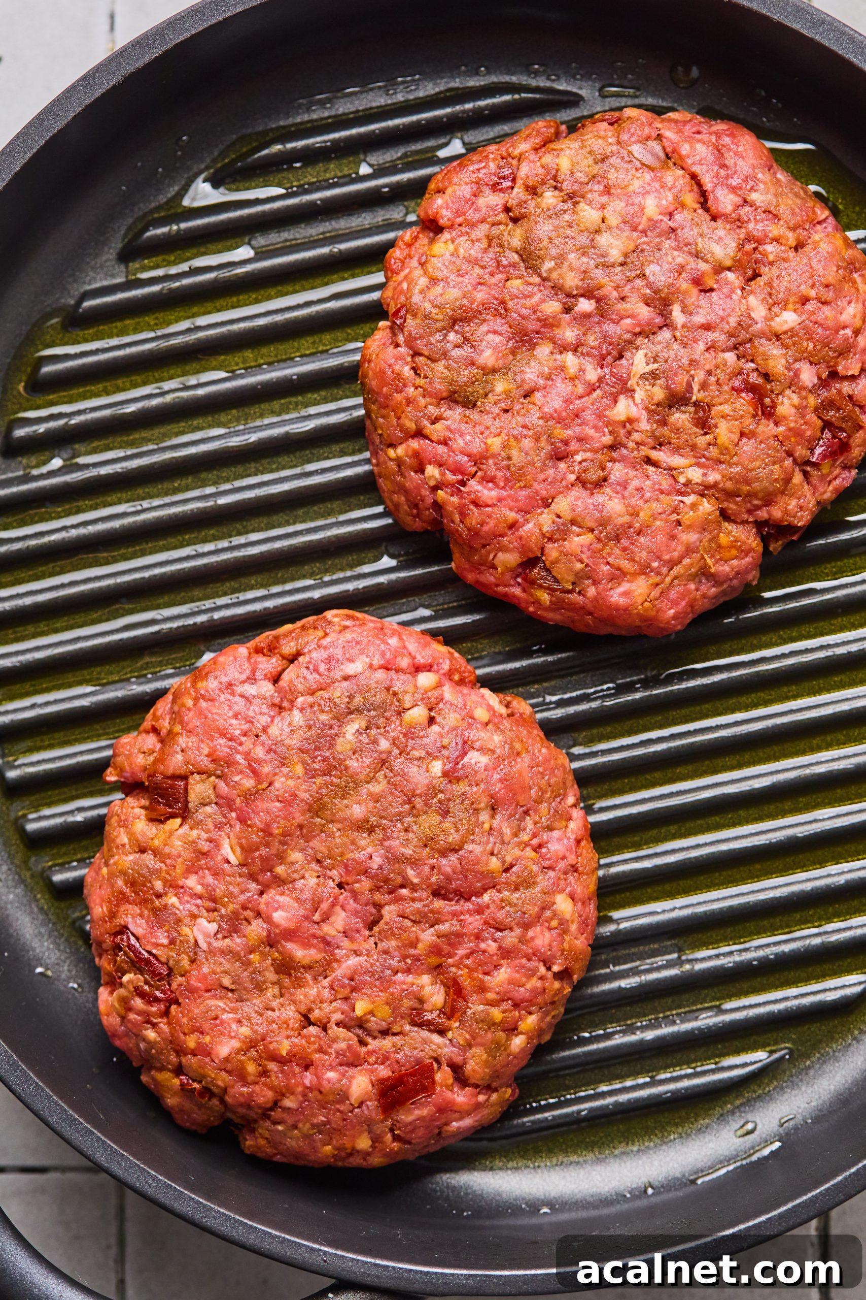 Smoky Chipotle Beef Burgers with Creamy Aioli 8 2 large chipotle beef burger patties sitting on a grill pan