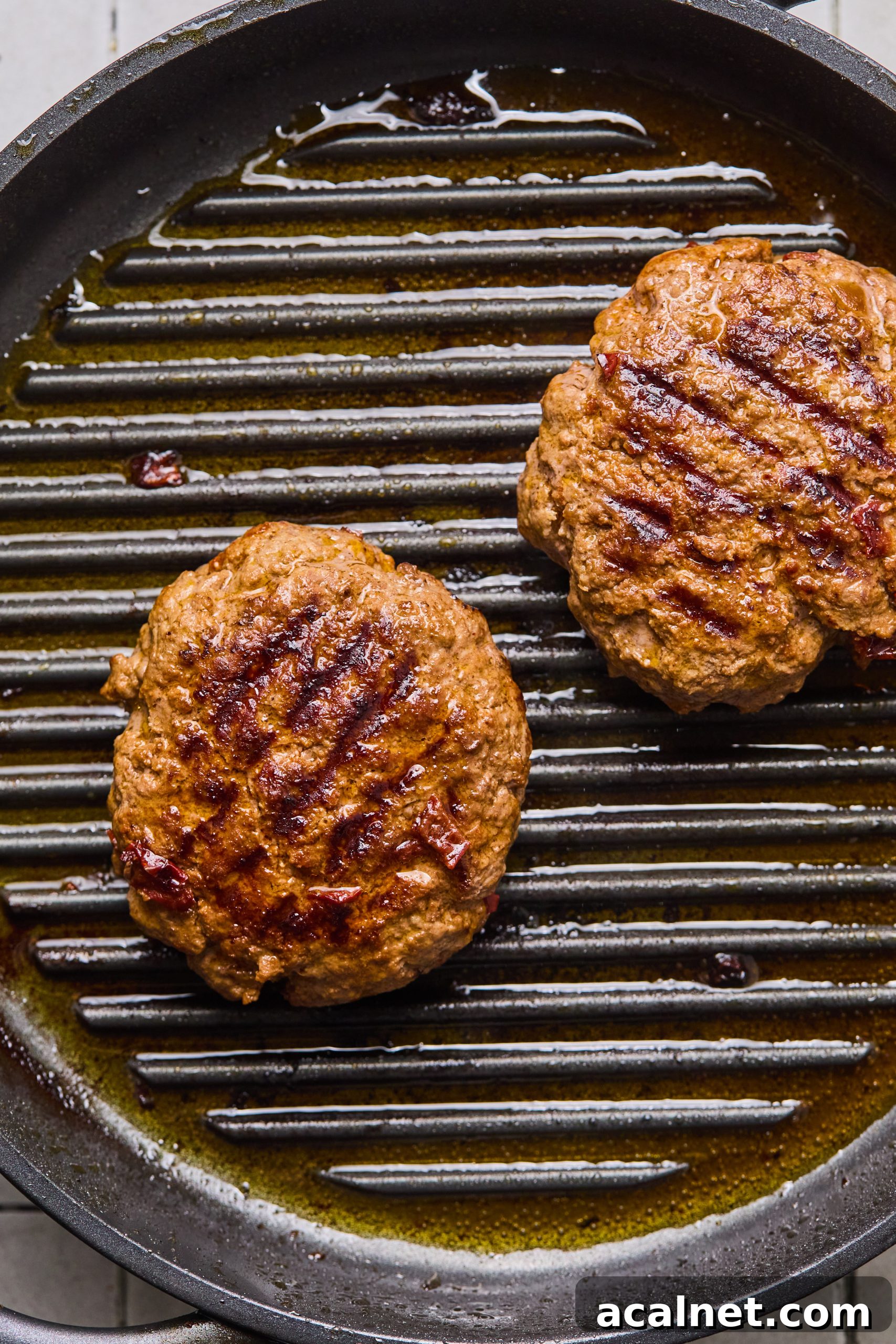 Smoky Chipotle Beef Burgers with Creamy Aioli 9 2 large grilled chipotle beef burger patties sitting on a grill pan