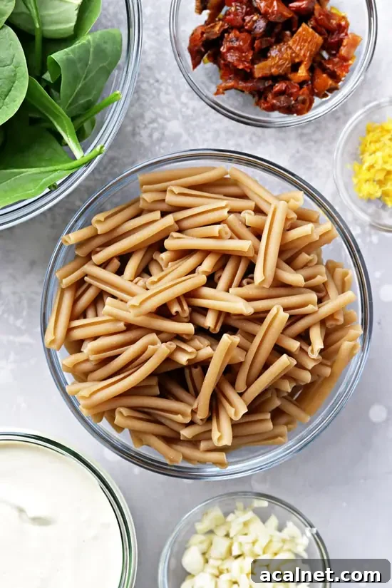 Veggies, sauce and dry pasta in small bowls.