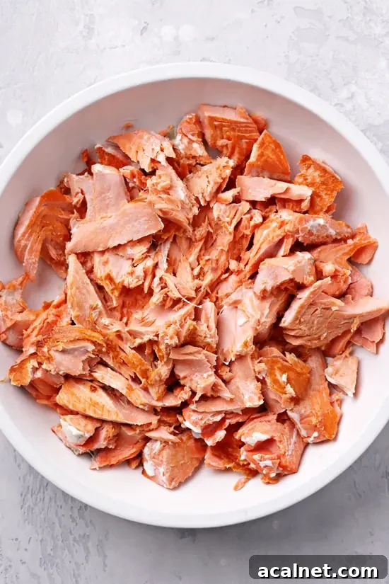 Flaked cooked salmon in a bowl.