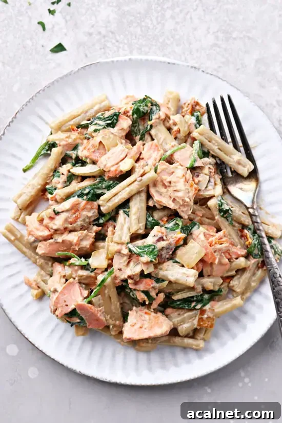 A white plate with Dairy Free Seafood Pasta and a fork.